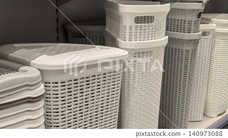 White plastic rattan weave laundry hampers stacked on store shelf White plastic rattan weave laundry hampers stacked on store shelf 140973088