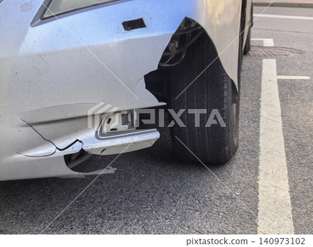 Damaged car bumper and exposed tire after collision in parking lot 140973102