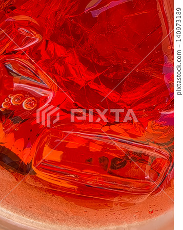Abstract macro of red fizzy drink with ice cubes in glass Abstract macro of red fizzy drink with ice cubes in glass 140973189