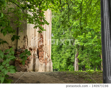 Old castle ruin walls in lush green park with trees framing the scene 140973198