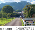 A residential area and road at the foot of a mountain. 140973711