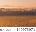 A field of rapeseed flowers illuminated by the rising sun amid the morning mist. 140973971