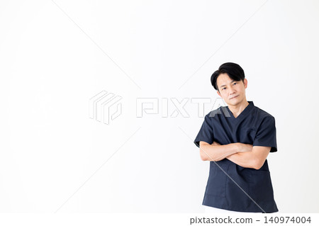 一位身穿深藍色手術服的中年男醫生,神情憂慮。 一位身穿深藍色手術服的中年男醫生,神情憂慮。 140974004