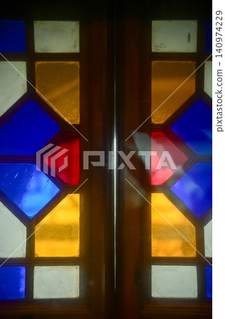 Colorful classic glass window with grid. Colorful abstract stained glass window pattern background. Classic pattern. Building abstract. Building background. Colorful classic glass window with grid. Colorful abstract stained glass window pattern background. Classic pattern. Building abstract. Building background. 140974229