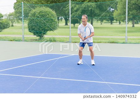 Senior men playing tennis on an outdoor court - a healthy and active lifestyle Senior men playing tennis on an outdoor court - a healthy and active lifestyle 140974332