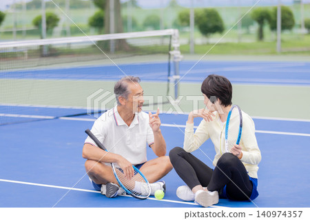 一對老年夫婦在網球場上休息 一對老年夫婦在網球場上休息 140974357
