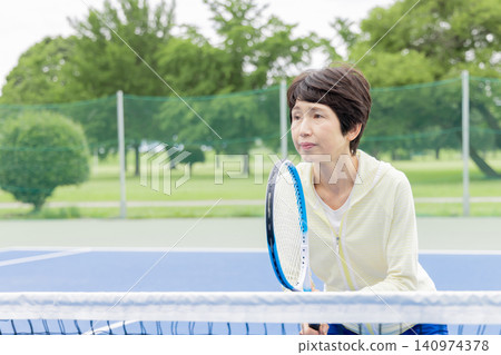 資深女子網球選手站在網前 140974378