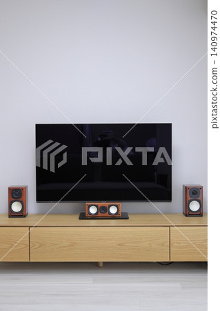 A large TV and home theater system mounted on a wooden TV stand. A large TV and home theater system mounted on a wooden TV stand. 140974470