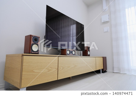 A large TV and home theater system mounted on a wooden TV stand. A large TV and home theater system mounted on a wooden TV stand. 140974471