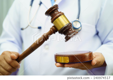 Asian doctor holding court hammer for and crime law justice, forensic medicine. 140974517