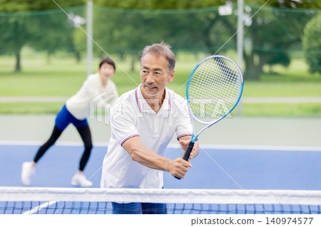 Senior tennis players playing doubles Senior tennis players playing doubles 140974577