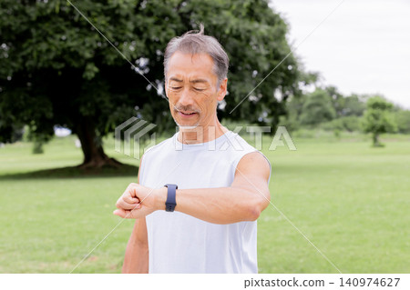 Active senior men check their exercise records with smartwatches Active senior men check their exercise records with smartwatches 140974627
