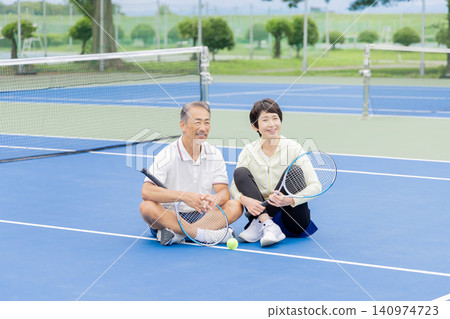 一對老年夫婦在網球場上休息 一對老年夫婦在網球場上休息 140974723