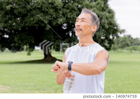 Active senior men check their exercise records with smartwatches Active senior men check their exercise records with smartwatches 140974739