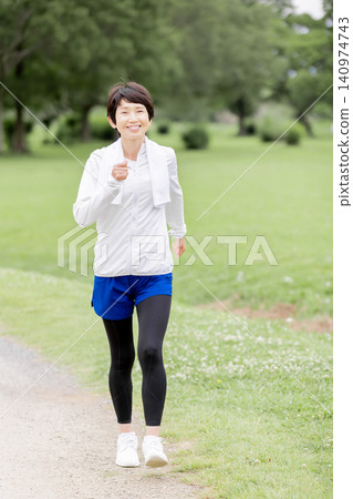 A smiling, active senior woman enjoying a walk in the park. A smiling, active senior woman enjoying a walk in the park. 140974743