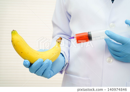 Male doctor making an injection to a banana with a syringe, penis health. Male doctor making an injection to a banana with a syringe, penis health. 140974846