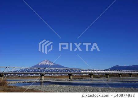 The Shinkansen bullet train and the Fujikawa Railway Bridge running in front of the mountain range of Mt. Fuji and Mt. Ashitaka. January. Mt. Fuji 2073, Mt. Ashitaka, Shinkansen, Fujikawa Railway Bridge. The Shinkansen bullet train and the Fujikawa Railway Bridge running in front of the mountain range of Mt. Fuji and Mt. Ashitaka. January. Mt. Fuji 2073, Mt. Ashitaka, Shinkansen, Fujikawa Railway Bridge. 140974988