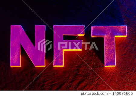 Bold NFT text with vibrant neon lighting effect on dark background for crypto concept Bold NFT text with vibrant neon lighting effect on dark background for crypto concept 140975606