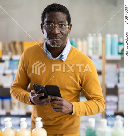 Middle-aged man checking list of medications on phone in drugstore Middle-aged man checking list of medications on phone in drugstore 140976094