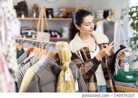 Young woman choosing gloves in clothing store Young woman choosing gloves in clothing store 140976107