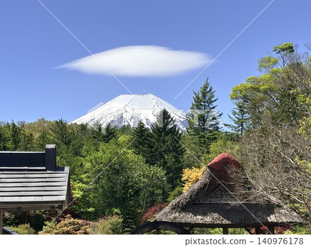 初夏時節,富士山上飄著莢狀雲,映襯著湛藍的天空。 初夏時節,富士山上飄著莢狀雲,映襯著湛藍的天空。 140976178