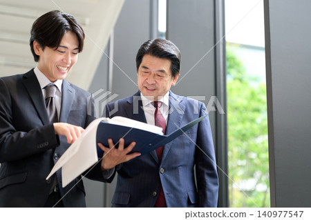 An Asian businessman giving an explanation while walking. An Asian businessman giving an explanation while walking. 140977547