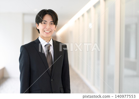 A young Asian businessman standing with a smile 140977553
