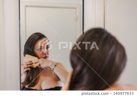 Woman Combing Hair - Daily Beauty Routine Woman Combing Hair - Daily Beauty Routine 140977633