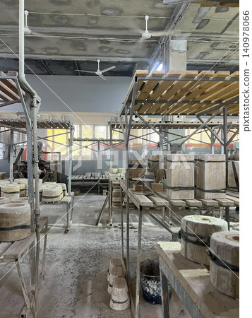 Ceramic workshop showcases tools and tables filled with clay pieces awaiting drying, creating a vibrant production environment Ceramic workshop showcases tools and tables filled with clay pieces awaiting drying, creating a vibrant production environment 140978066