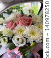 Fresh pink roses and white chrysanthemums arranged elegantly inside a car, capturing a moment of joy and beauty 140978250