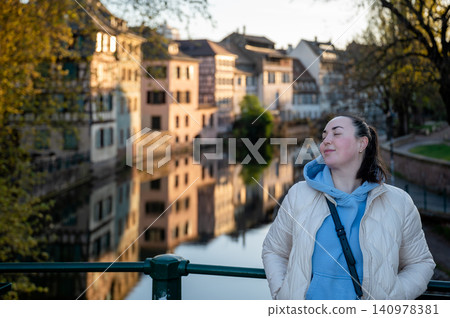 Woman Smiling on Bridge Riverside Timbered Houses Sunlit Woman Smiling on Bridge Riverside Timbered Houses Sunlit 140978381