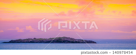 Island on the horizon. Rocks in the sea. Beautiful rocky sea landscape in evening. Wild nature Norway, seascape. Gradient color Island on the horizon. Rocks in the sea. Beautiful rocky sea landscape in evening. Wild nature Norway, seascape. Gradient color 140978454