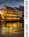 Illuminated Facade Above Shimmering Canal Reflections 140978588