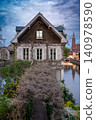 Historic Stone Facade Framed by Trimmed Wisteria Canal 140978590