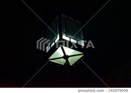Close-up of the Chinese classical lamp hanging on the ceiling at night. Light bulb. Interior design, decoration. Lighting equipment. Close-up of the Chinese classical lamp hanging on the ceiling at night. Light bulb. Interior design, decoration. Lighting equipment. 140979099