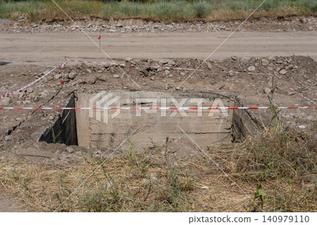 A site for excavation of soil for a concrete utility room, marked with warning tape, next to a rural road A site for excavation of soil for a concrete utility room, marked with warning tape, next to a rural road 140979110