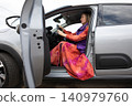 Driver woman with blonde hair sits in car moving gear ready to start driving. Horizontal. 140979760