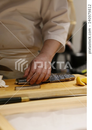 Chef Preparing Sushi on Wooden Board 140979812
