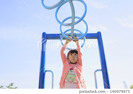 Infant (5-year-old) playing on a cloud ladder Infant (5-year-old) playing on a cloud ladder 140979973