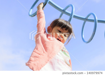 Infant (5-year-old) playing on a cloud ladder Infant (5-year-old) playing on a cloud ladder 140979974