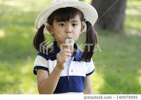 Infant blowing a dandelion (5 years old) Infant blowing a dandelion (5 years old) 140979995