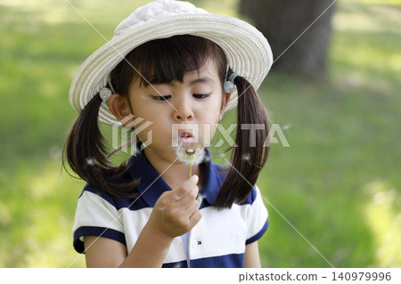 Infant blowing a dandelion (5 years old) Infant blowing a dandelion (5 years old) 140979996