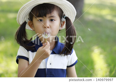 Infant blowing a dandelion (5 years old) Infant blowing a dandelion (5 years old) 140979997