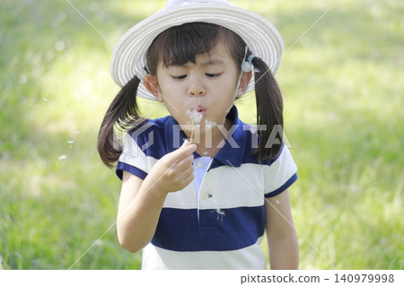 Infant blowing a dandelion (5 years old) Infant blowing a dandelion (5 years old) 140979998