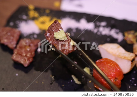 Gourmet Meat with Garlic Garnish on Slate Plate Gourmet Meat with Garlic Garnish on Slate Plate 140980036