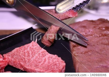 Steak Being Cut with Scissors and Tongs Steak Being Cut with Scissors and Tongs 140980046