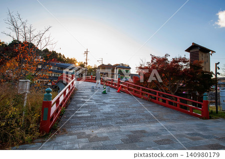 people cross Uji bridge to city with autumn maple leaves at sunset people cross Uji bridge to city with autumn maple leaves at sunset 140980179