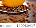 Cup of coffee and coffee beans on a white plate. dark background 140980417