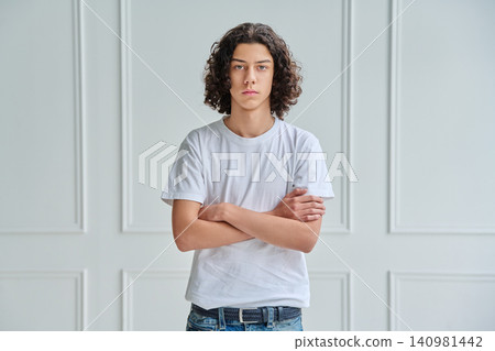 Teenage boy with curly hair in white t-shirt Teenage boy with curly hair in white t-shirt 140981442
