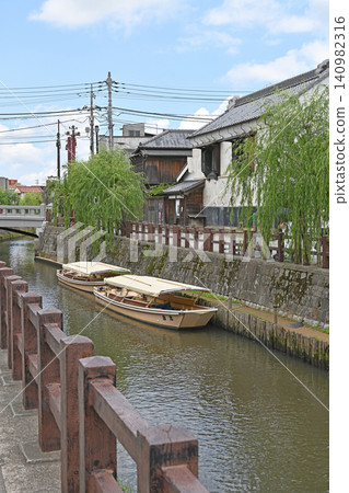 Sightseeing boats in the waterside town of Sawara: A traditional and beautiful landscape where boats resting on the Ono River are interwoven with white-walled storehouses and willow trees. 140982316